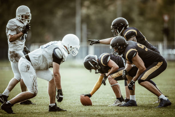 American football players on a beginning of the match. American football players confronting before the beginning of a match. offensive line stock pictures, royalty-free photos & images