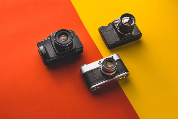 istock Creativity Retro Technology Concept. Film Cameras On Red And Orange Background, Top View 947724744