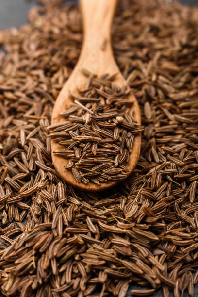 istock Seeds of cumin on a dark stone background 947724960