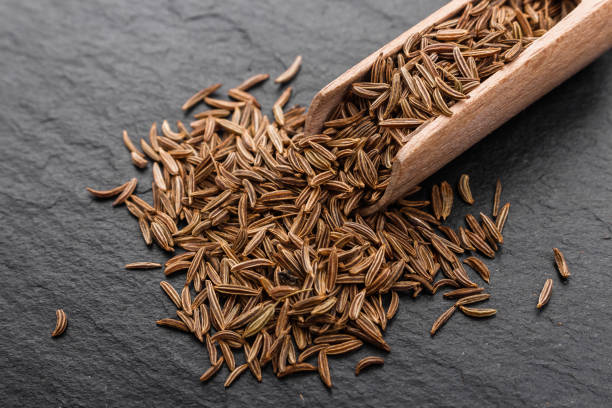 istock Seeds of cumin on a dark stone background 947724998
