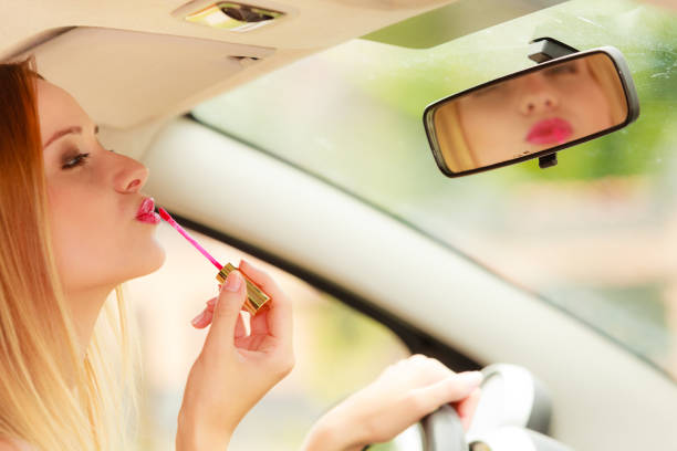 istock Woman applying makeup while driving her car 947725268