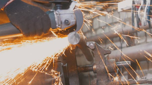 istock Blacksmith worker in forg making detail with circular saw 947726148