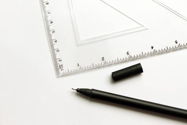 istock Mathematical accessories. Triangle ruler for math and black pen for school on a white background. School supplies. Office supplies for work or study. Geometric pattern. Math. 947728862