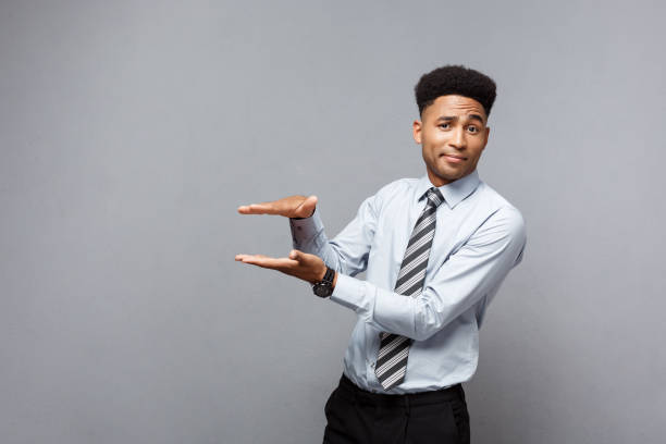 istock Business Concept - Amazed African American holding both hands on side presenting projects over grey background. 947729908
