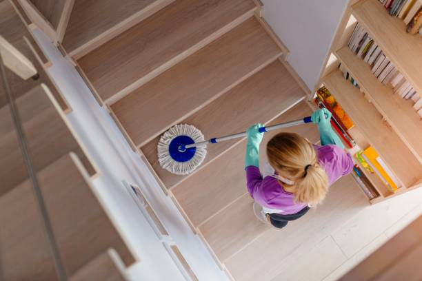 jeune femme en tablier blanc, nettoyant les escaliers. - chores wood wet indoors photos et images de collection