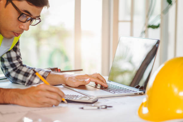 istock architect man working with laptop and blueprints,engineer inspection in workplace for architectural plan,sketching a construction project ,selective focus,Business concept. 947732914