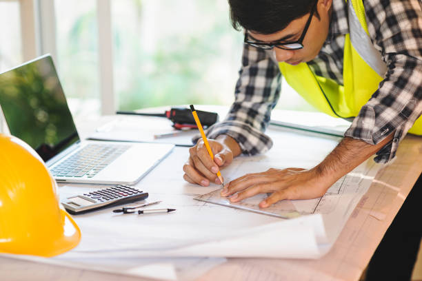 istock architect man working with laptop and blueprints,engineer inspection in workplace for architectural plan,sketching a construction project ,selective focus,Business concept. 947732932