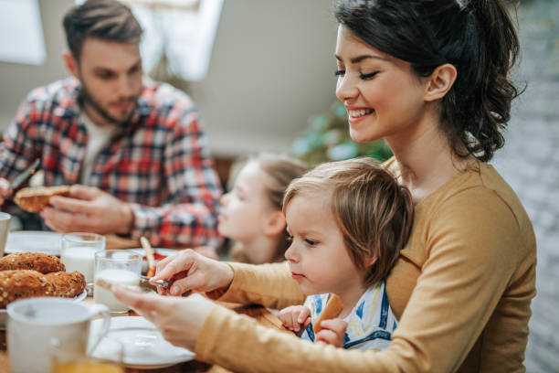 istock Happy mother preparing her son breakfast at dining table. 947738044