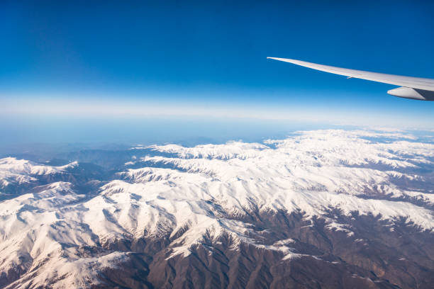 istock Wing of an airplane flying above the clouds with blue sky. 947739096