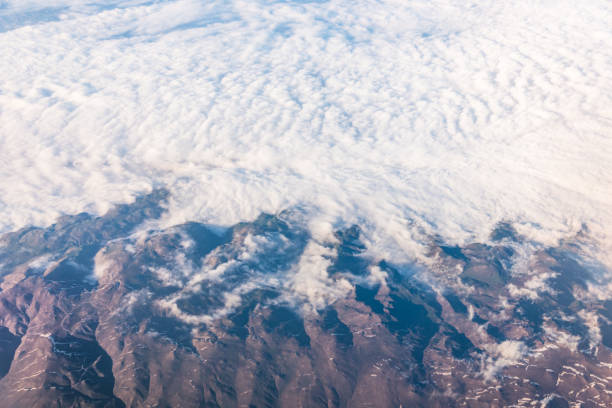 istock Wing of an airplane flying above the clouds with blue sky. 947739224