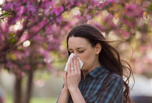 istock Woman having allergy reaction on blooming tree 947749326