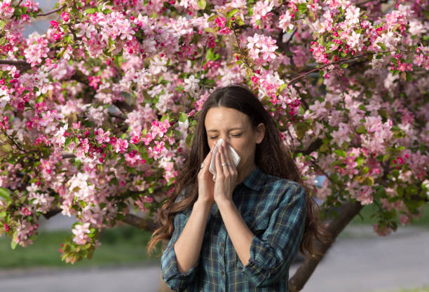 istock Woman having allergy reaction on blooming tree 947749454