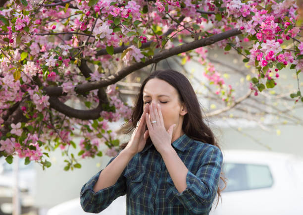 istock Woman having allergy reaction on blooming tree 947749586