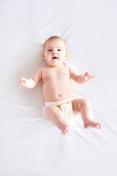 istock Naked baby lying on back at studio shot 947752738