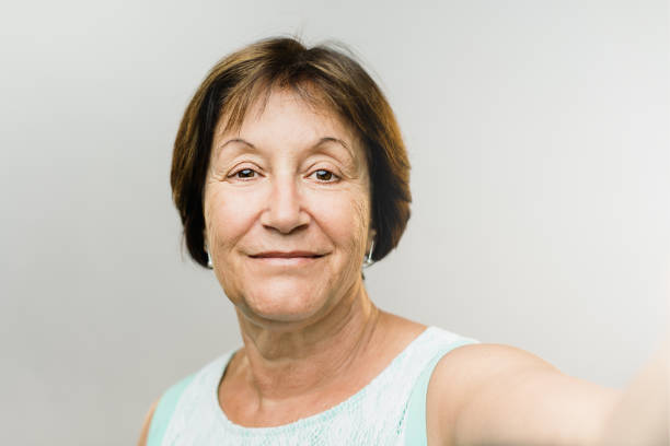 Beautiful happy mature woman taking selfie