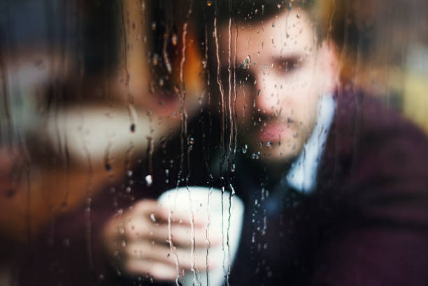 istock Contemplating man looking out the window 947766682