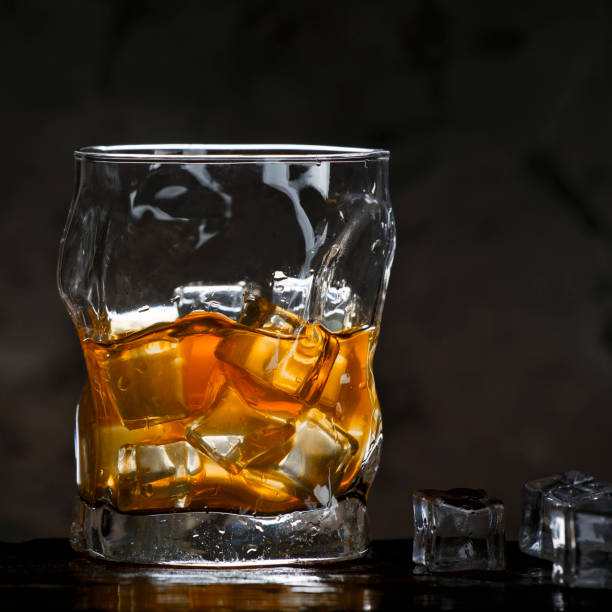 alkohol w szkle z lodem na ciemnym tle - brandy bottle alcohol studio shot zdjęcia i obrazy z banku zdjęć