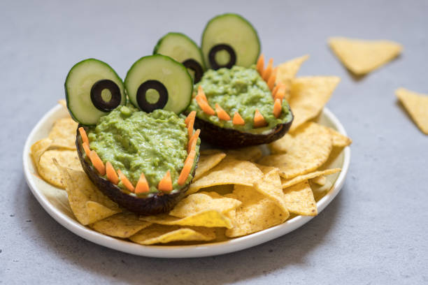 istock Funny alligator avocado guacamole dip and nachos 947776054
