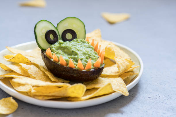 istock Funny alligator avocado guacamole dip and nachos 947776228