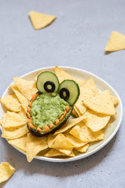 istock Funny alligator avocado guacamole dip and nachos 947776272