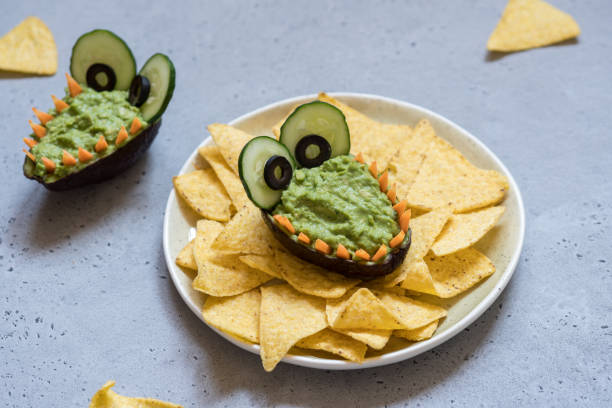 istock Funny alligator avocado guacamole dip and nachos 947776352