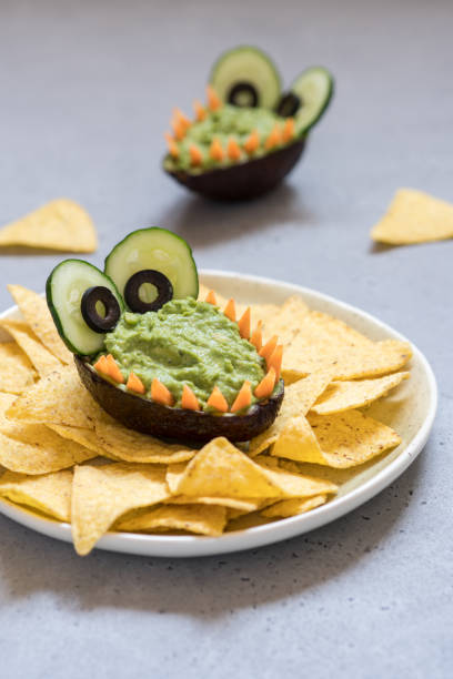 istock Funny alligator avocado guacamole dip and nachos 947776392
