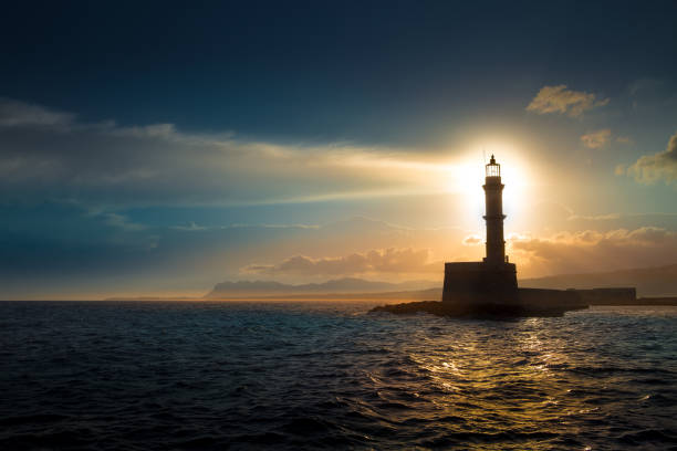 a beautiful night sky behind a shining lighthouse. crete, greece - direction sea lighthouse landscape imagens e fotografias de stock
