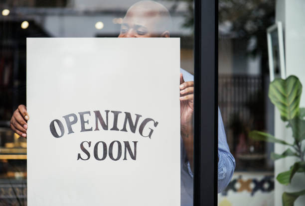 homme mettant sur magasin ouverture bientôt signe - opening soon photos et images de collection