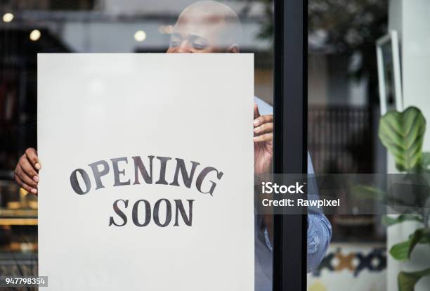 Foto de Homem Colocando Na Abertura Em Breve Sinal Loja e mais fotos de stock de Loja - Loja, Restaurante, Novo