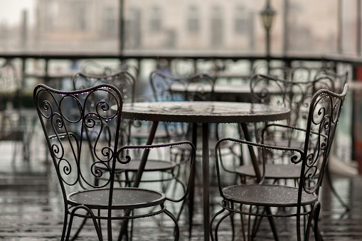 Vacant chairs and tables at a restaurant in the city.