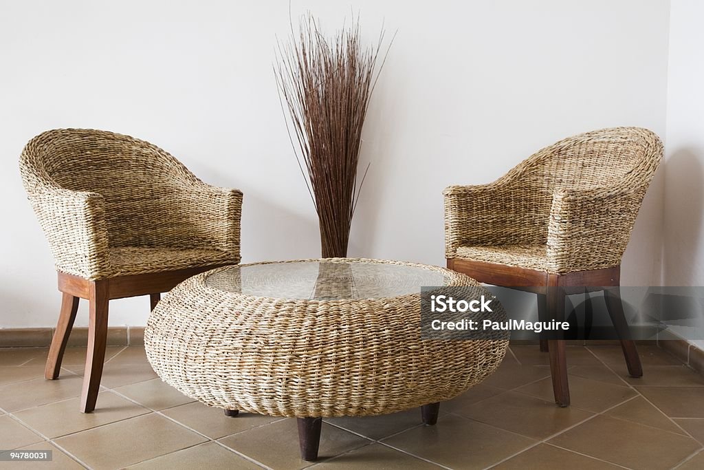 Wicker furniture against white wall background Rattan patio furniture against a white wall Table Stock Photo