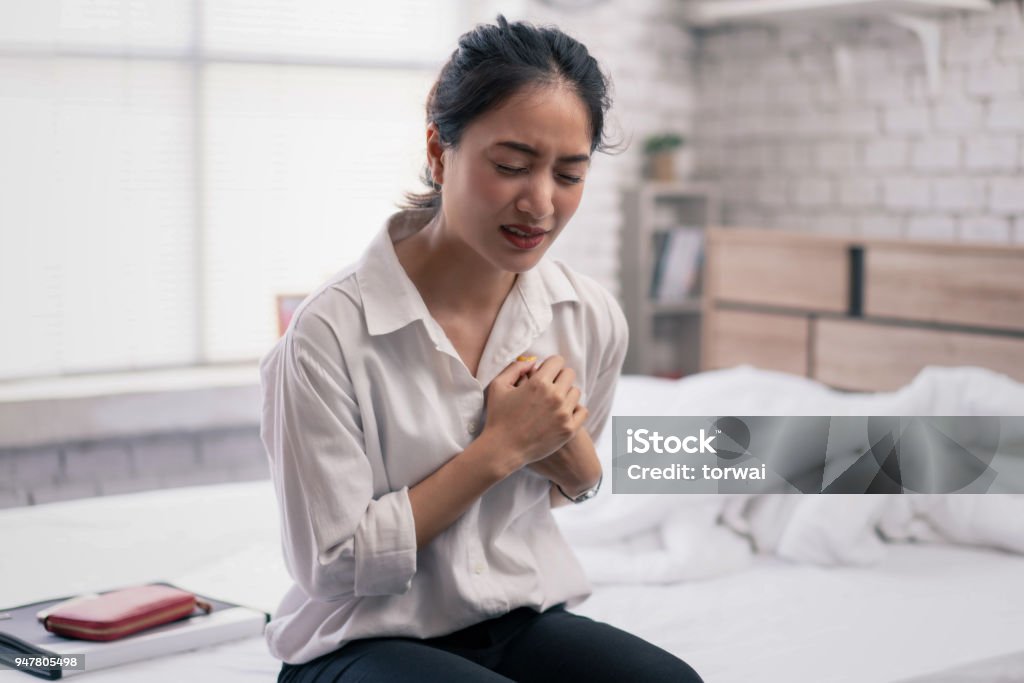The businessman is unable to work. She is sick and heart attack in bed. Heart Disease Stock Photo