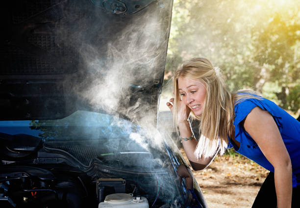 istock Smoke pours from young woman's car engine 947805730