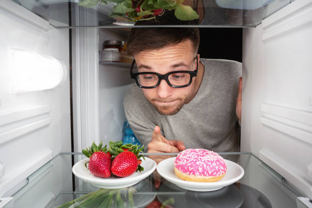 istock Man choosing between fruits and candy 947810290