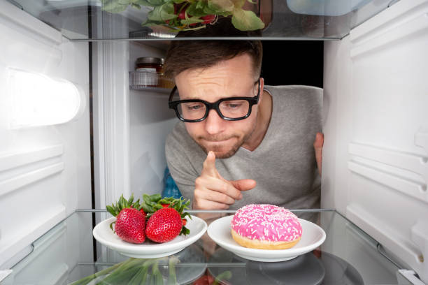 istock Man choosing between fruits and candy 947810302