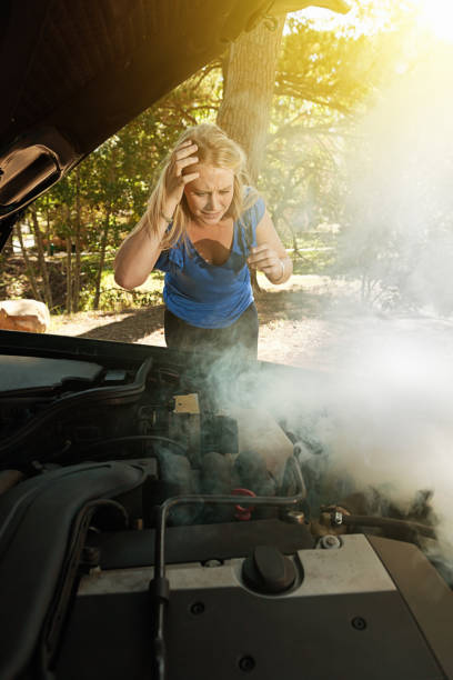 istock Smoke pours from young woman's car engine 947810976