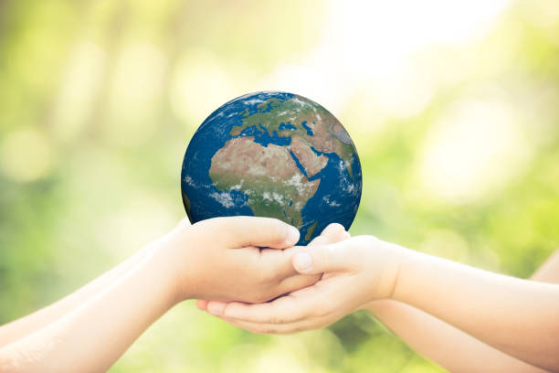 istock Child holding Earth planet in hands 947811762