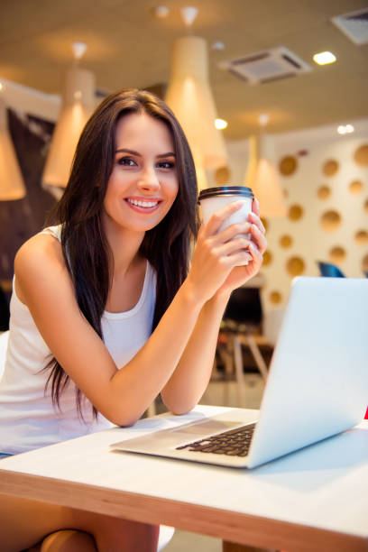 istock Young woman with laptop  in cafe having coffee break 947812360
