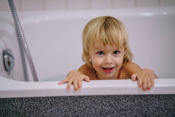 istock Cute boy enjoying in a bathtub looking at camera. 947816038