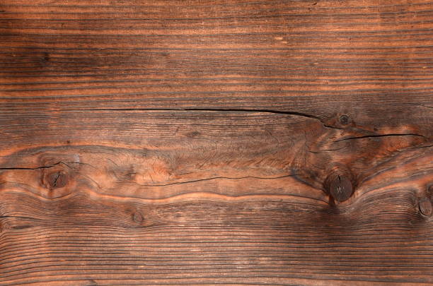 istock Weathered cracked knotted wood background 947831142
