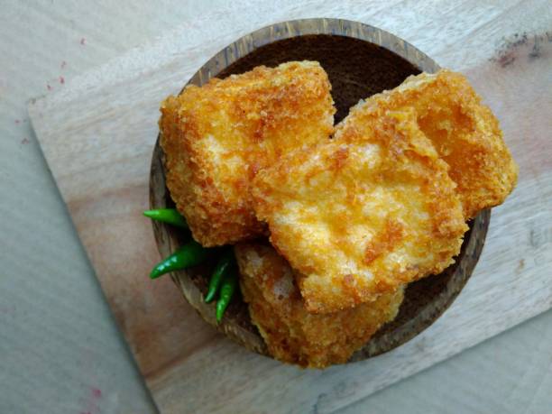 istock flat lays or top view, tahu sumedang (Fried Tofu) from west java,  indonesia with green hot chili at Wooden small bowl 947836624
