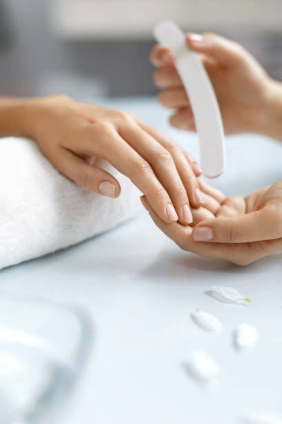 istock Closeup Beautiful Female Hands Filing Nails With File. Manicure 947843108