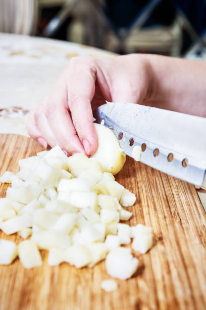 istock Woman's hand with a knife cutting the boiling potatoes 947843916