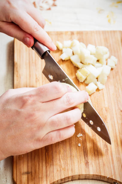 istock Woman's hand with a knife cutting the boiling potatoes 947844746