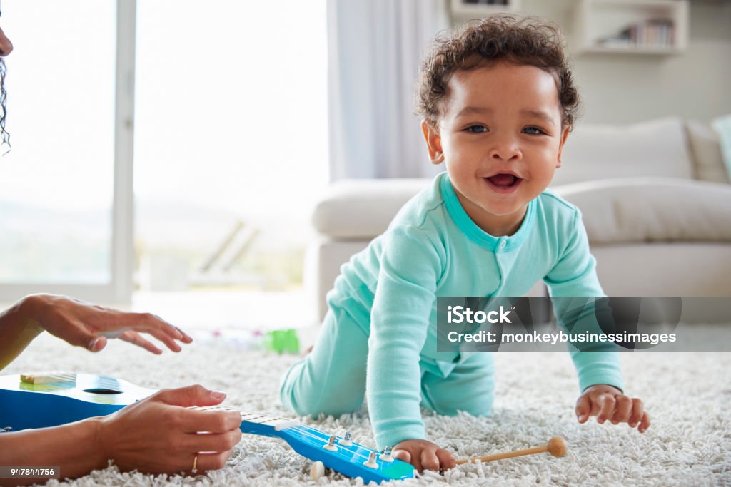 Mixed race mum and toddler son playing at home, close up Baby - Human Age Stock Photo