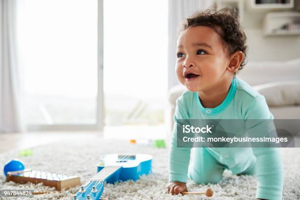 Happy Mixed Race Toddler Boy Crawling In Sitting Room Stock Photo - Download Image Now