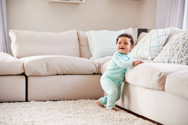 Happy mixed race toddler boy playing in sitting room