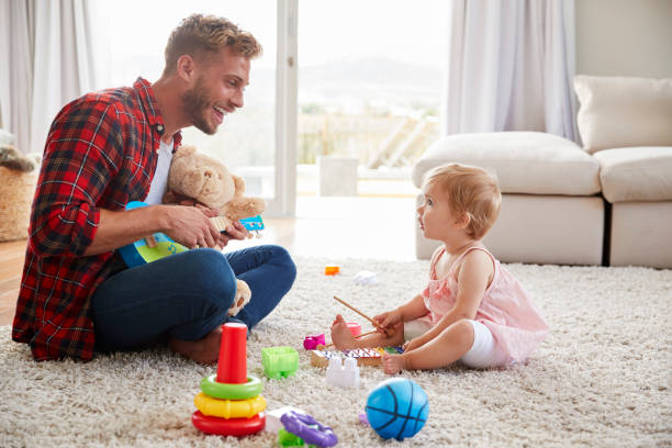 istock Father and young daughter play instruments in sitting room 947845112