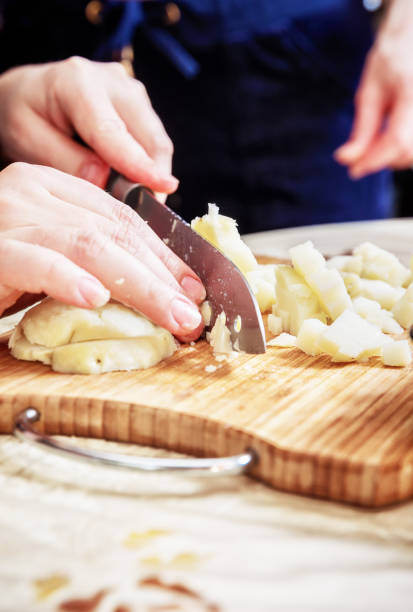 istock Woman's hand with a knife cutting the boiling potatoes 947845186