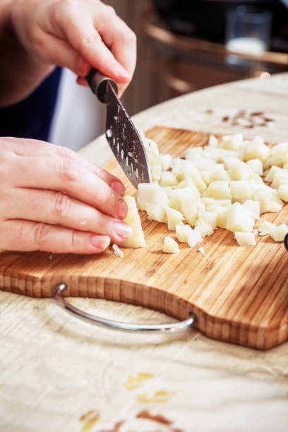 istock Woman's hand with a knife cutting the boiling potatoes 947845460